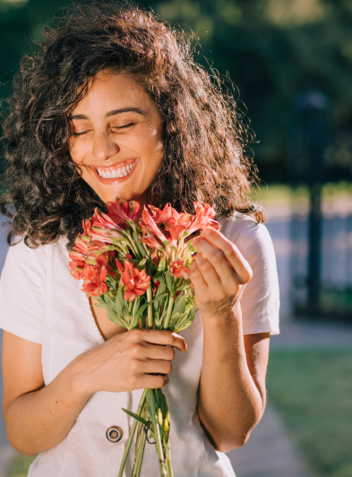 mulher sorrindo segurando flores